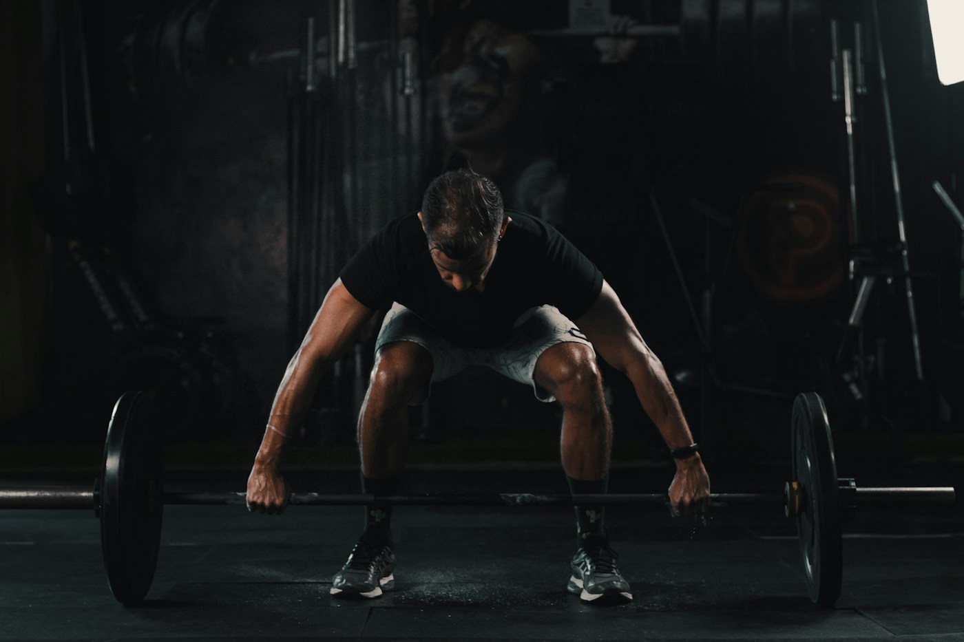 Athlete preparing a barbell lift on the gym floor